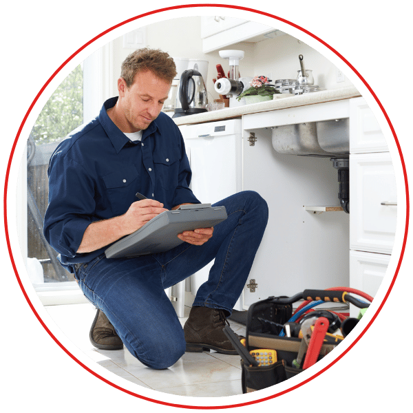 man kneels by sink cabinet to fill out estimate paper