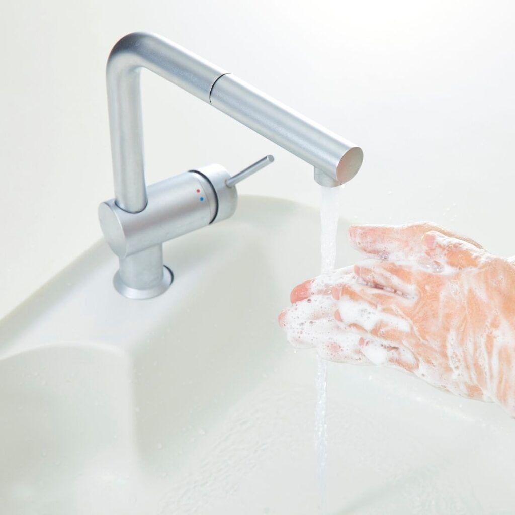 person washing hands with modern sink